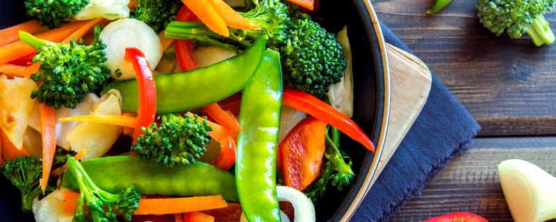 Broccoli, snap peas, carrots and peppers in a skillet